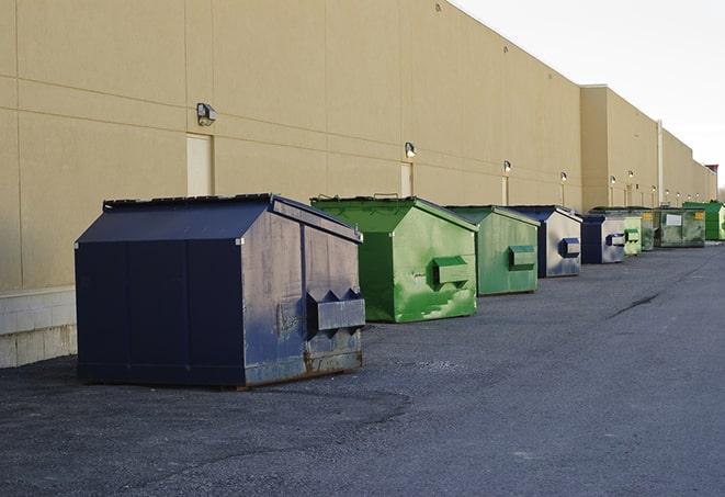 a row of blue construction dumpsters on a job site in Bradford, RI